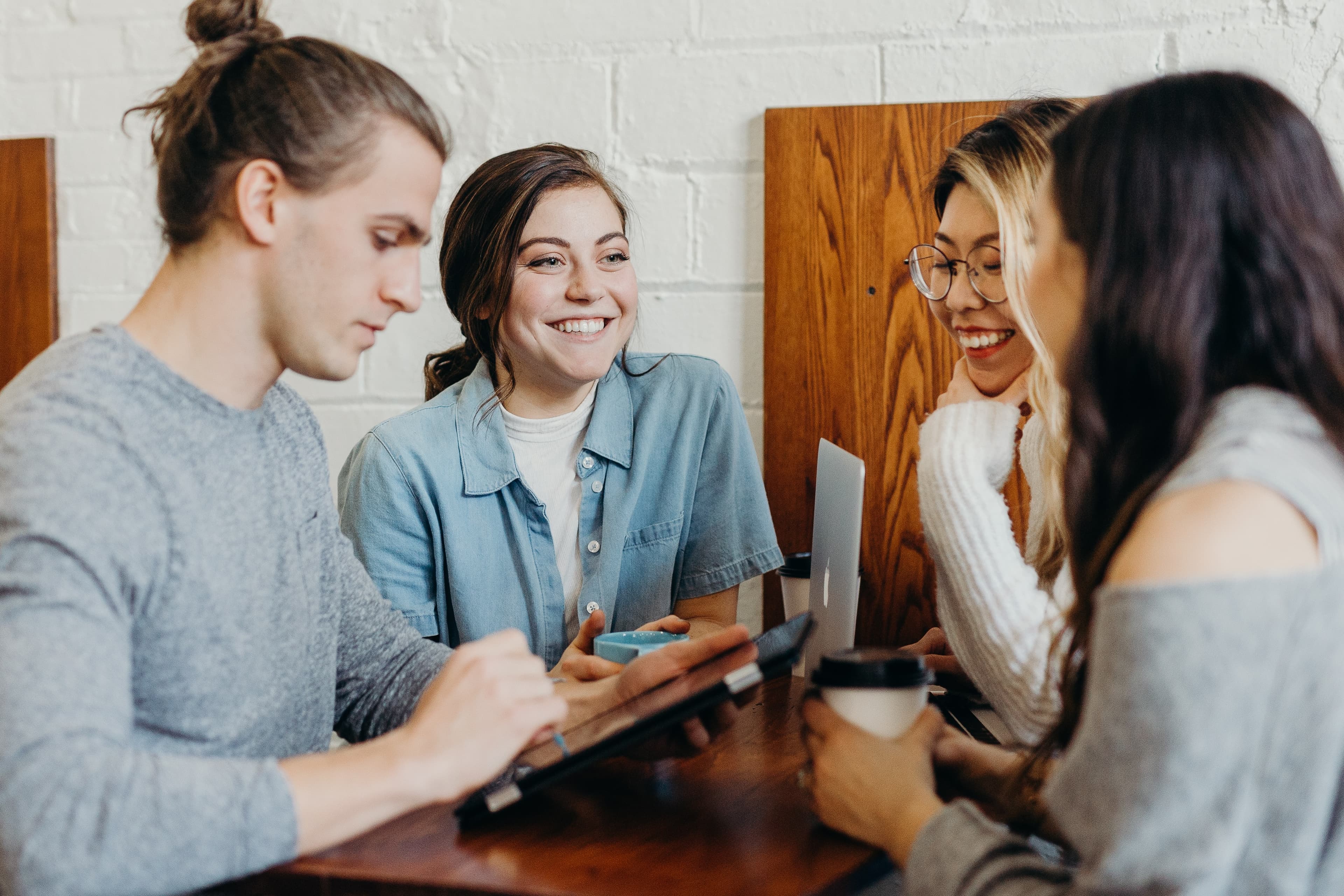 Group of Creators Smiling and Socializing In Coffee Shop with their IPads and Macbooks